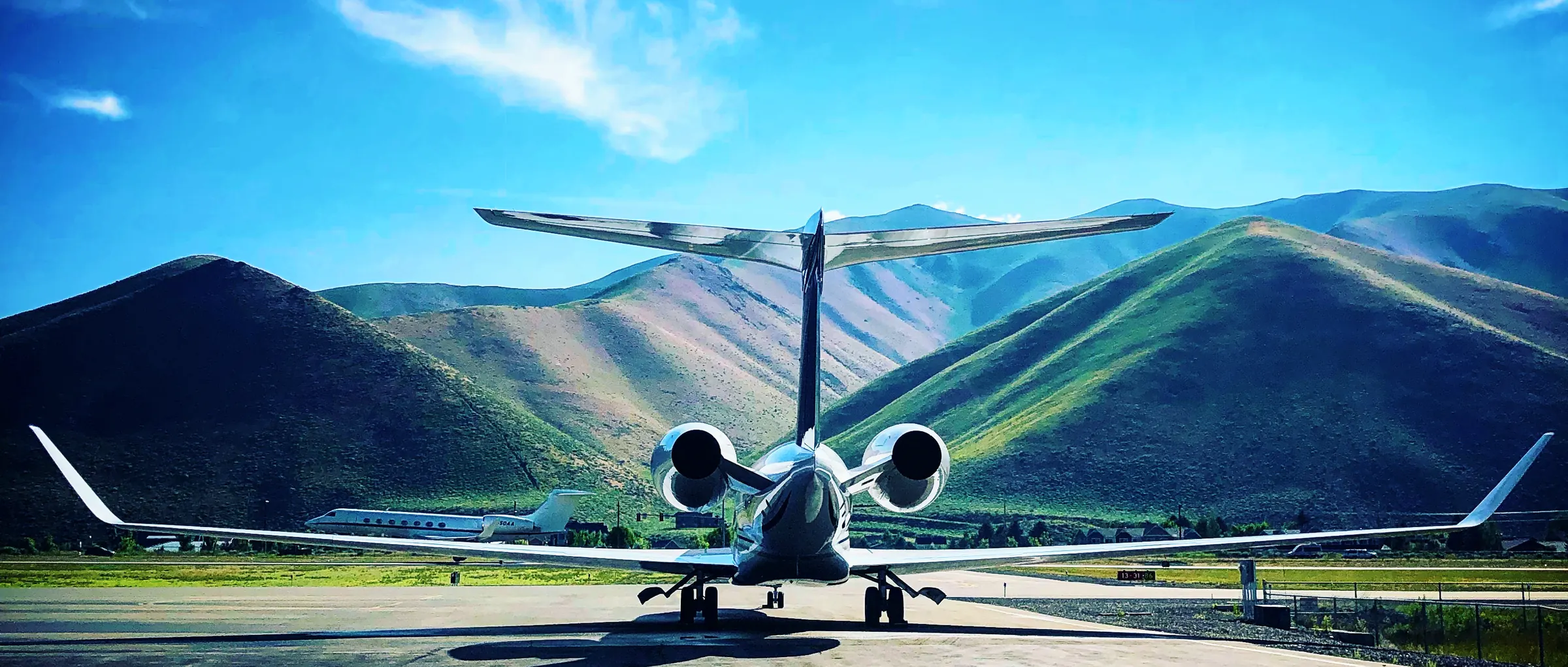Business jet on the ramp with mountains behind